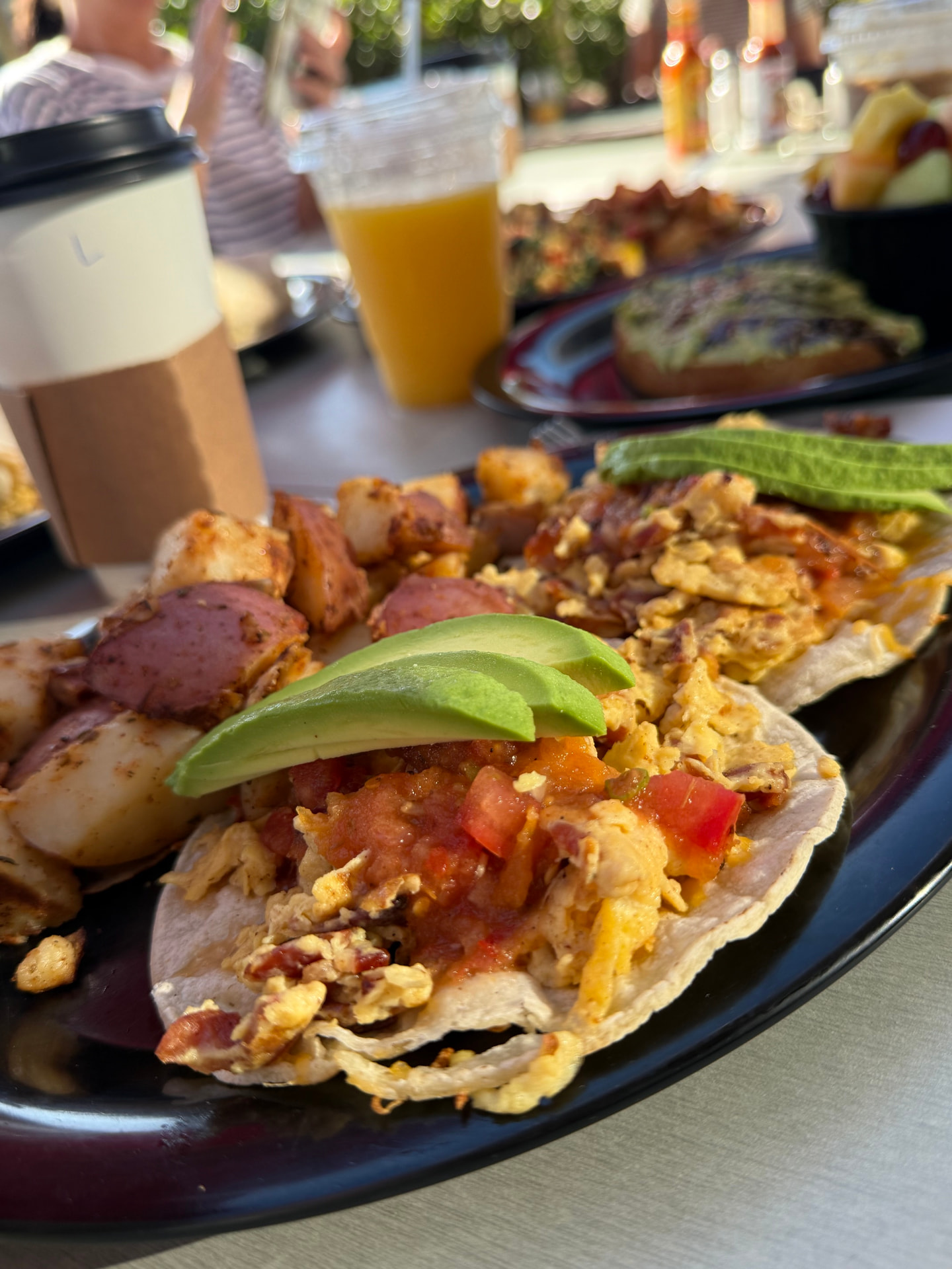 Breakfast tacos topped with salsa and avocado at Rooster Cafe